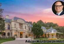 Adrian Wojnarowski House Tour: Inside the ESPN Legend’s Luxurious Home A large, luxurious French château-style mansion with a central dome and manicured front gardens under a warm sunset sky, featuring text overlaid at the bottom reading "Adrian Wojnarowski House"