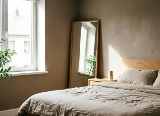 11 Bedroom Mirror Ideas That Make Your Room Look Bigger & Brighter Bedroom mirror ideas with a full-length mirror reflecting natural light in a small bedroom