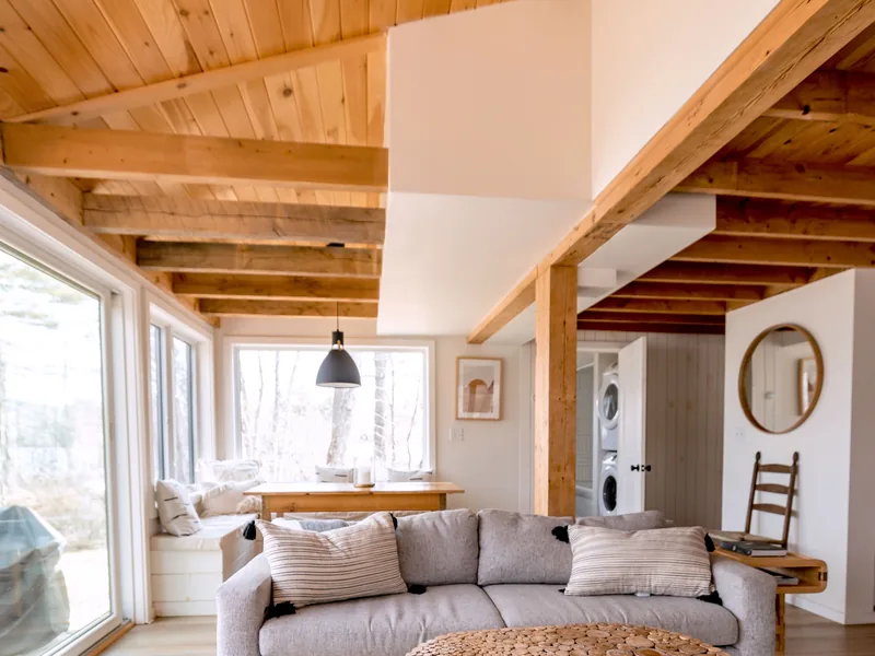 The Ranch That Came Back Off the Market in Three Months 3 An open living room with exposed wood beams and neutral tones
