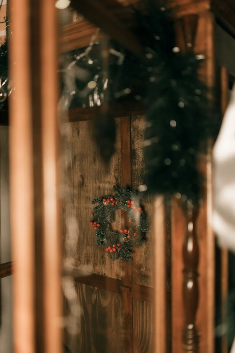 A Small Room, Dressed for December, That Still Works Every Morning 5 Small wreath with red berries on a wooden door