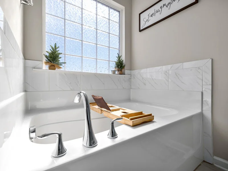 A Small Room, Dressed for December, That Still Works Every Morning 8 Bright tidy bathtub with clear surfaces and two small potted trees on the window sill
