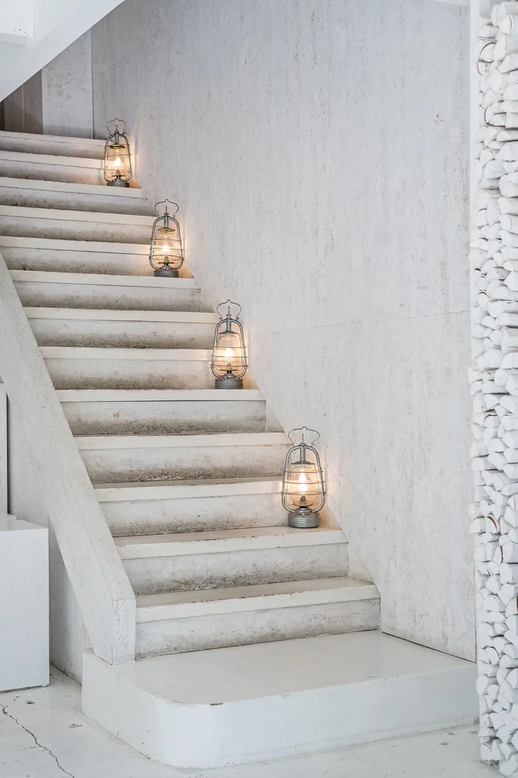 Glowing lanterns set one per step up a white staircase