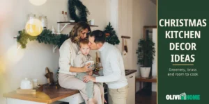 Christmas kitchen decor ideas with a counter tray, evergreen garland, a wreath and a small tree in a warm family kitchen.