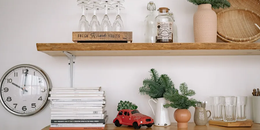 A Warm, Workable Holiday Kitchen: Greenery, Brass and Room to Cook 1 Christmas kitchen shelf decor with evergreen stems in vases and a small red car carrying a tree.
