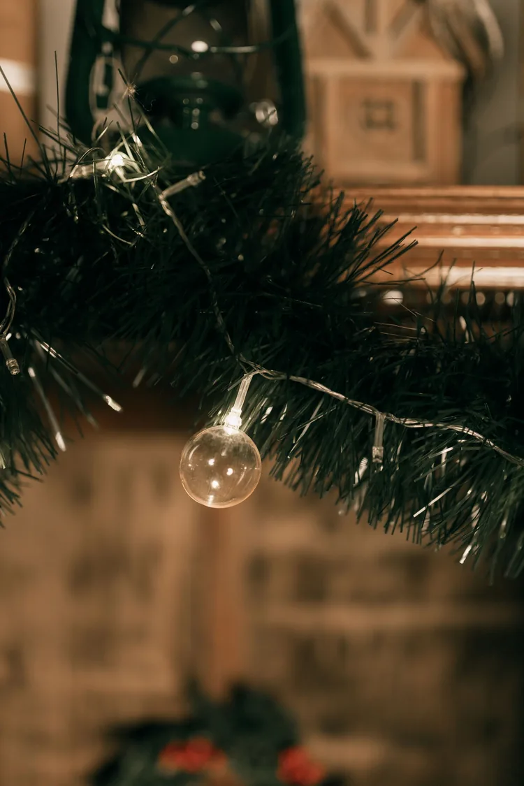 Warm globe lights woven through a dark green Christmas garland