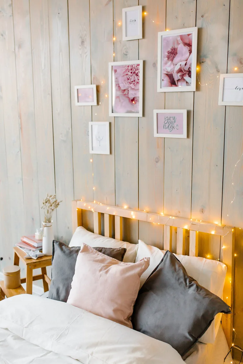 A Calm, Green Holiday Bedroom You Can Actually Sleep In 5 Warm fairy lights strung along a wooden headboard and up a panelled wall above a bed
