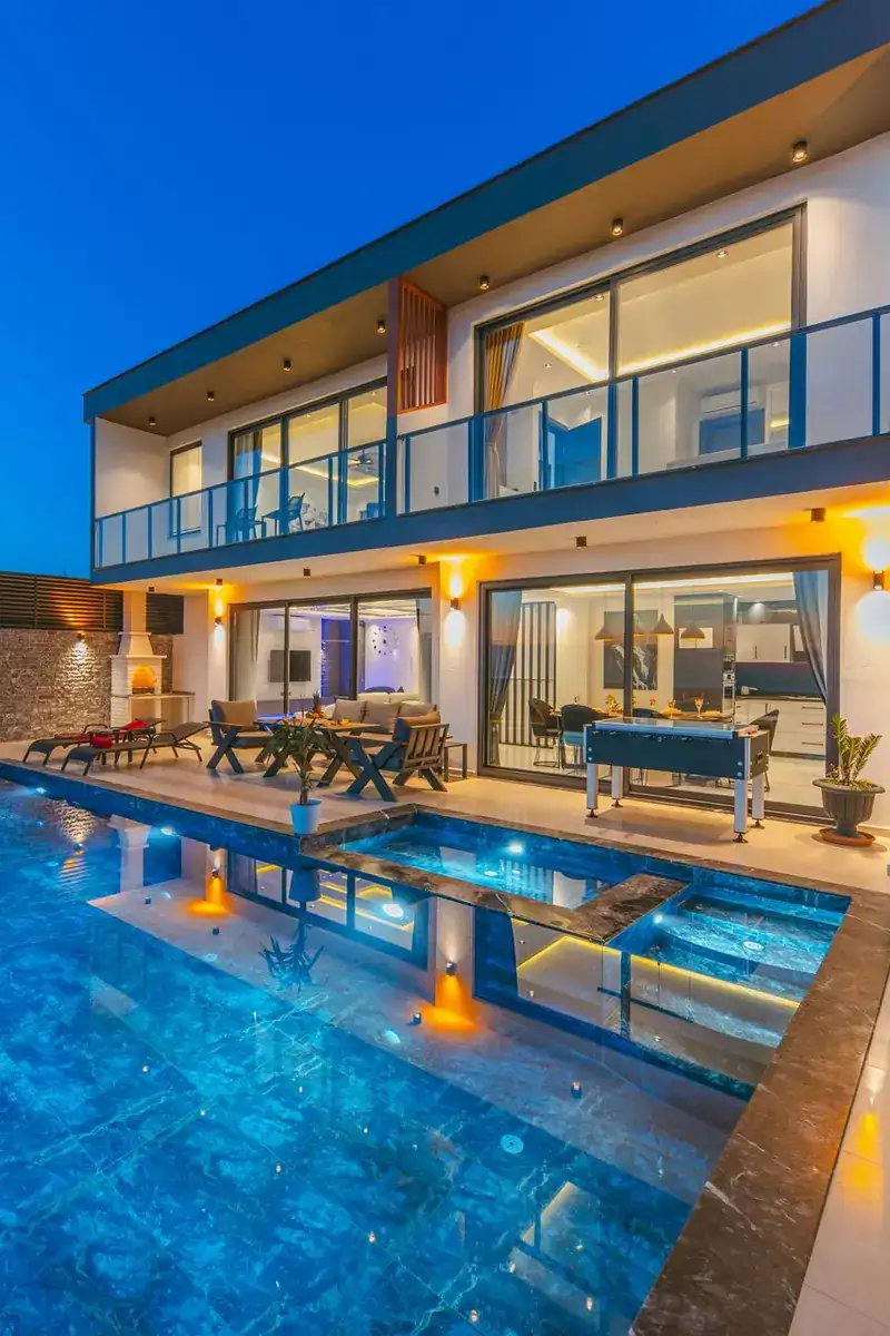 The $37.995M Investment House Its Owner Never Moved Into 1 A modern mansion with glass walls and terraces above an illuminated pool at dusk