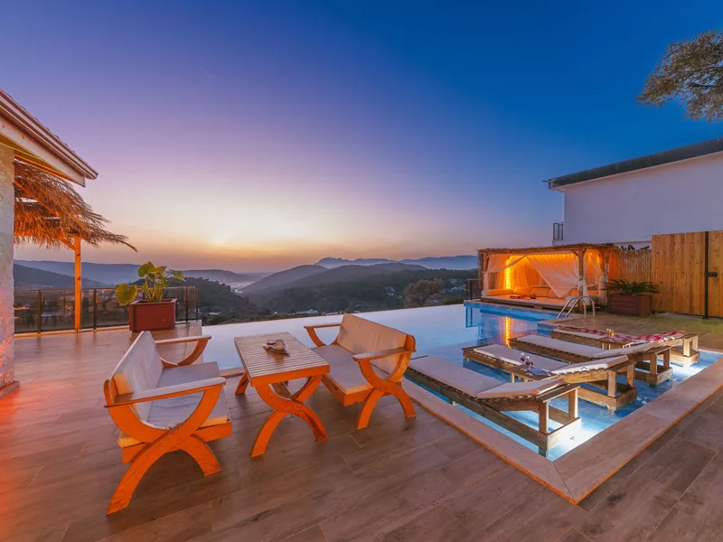 The $37.995M Investment House Its Owner Never Moved Into 3 An infinity pool and terrace with lounge chairs and mountain views at sunset