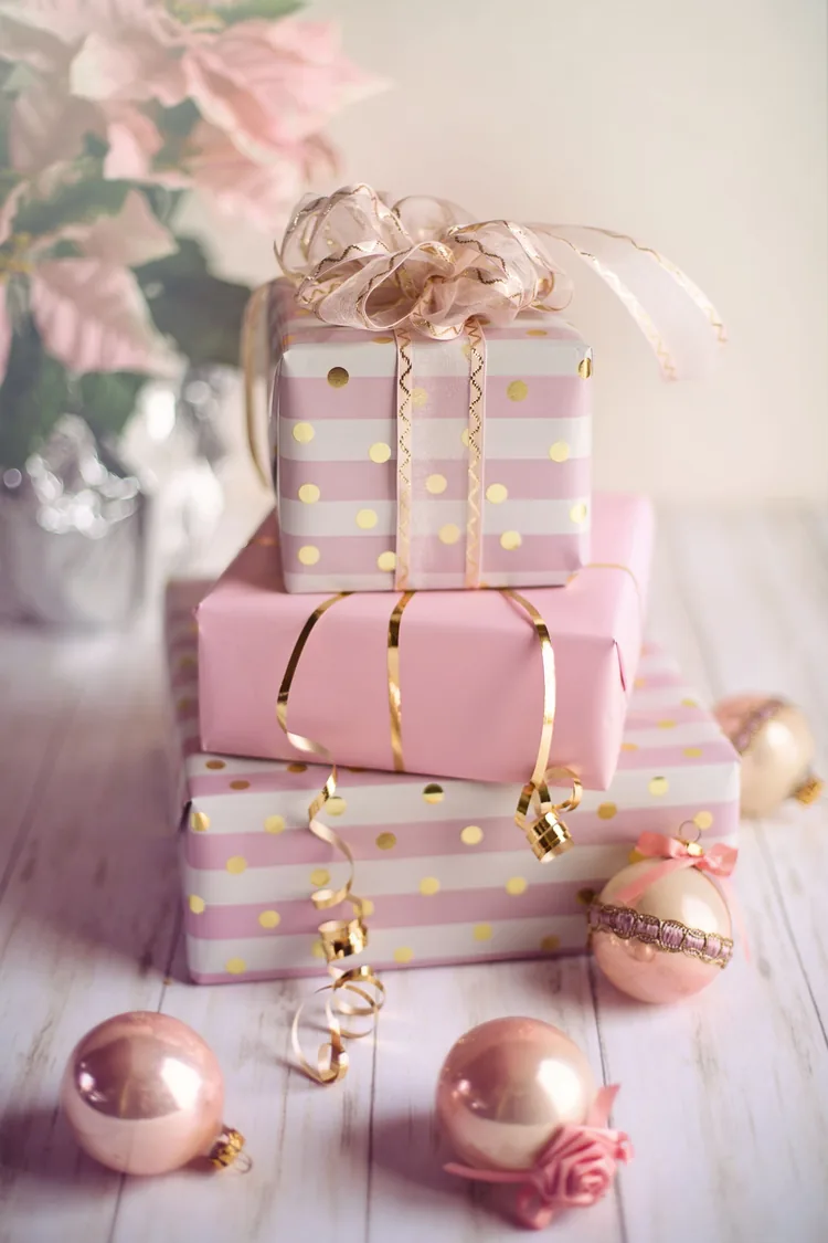 7 Ways to Make Pink Feel Like Christmas, Not a Party 6 Pink wrapped gifts in blush, cream and gold paper with gold ribbon.