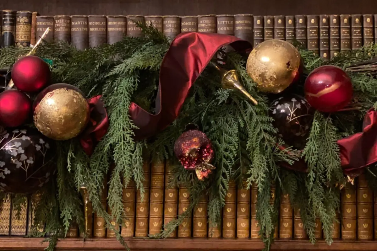A Festive Small Room That Still Works for Sitting, Walking and Gathering 3 Christmas shelf garland with red and gold ornaments on a bookshelf
